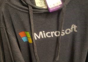 一张带有 Microsoft 标签和徽标的灰色运动衫的照片。